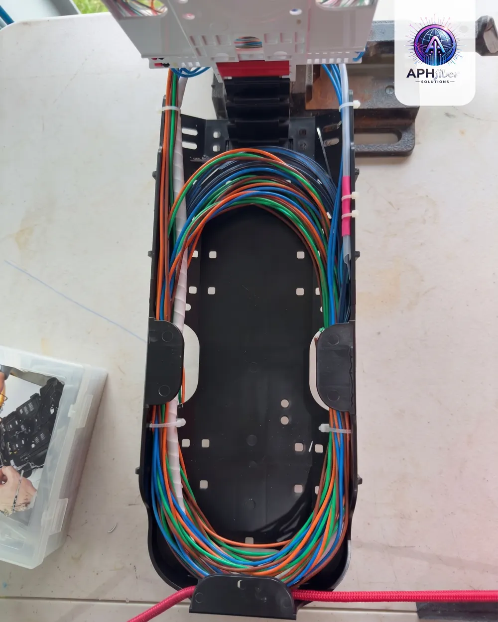 Coiled color-coded fiber strands inside an open splice enclosure