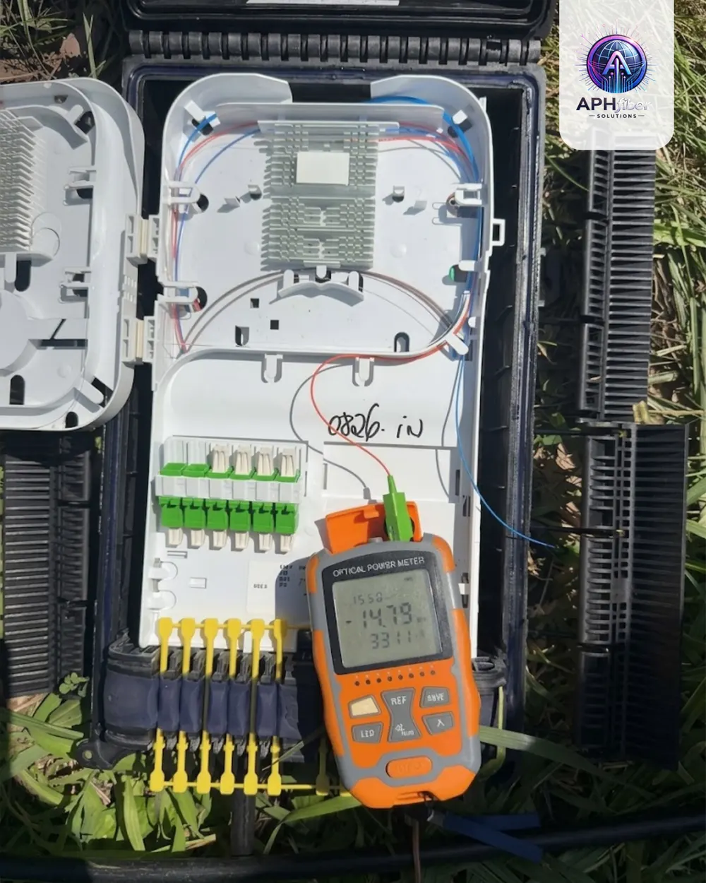 APH Fiber technician measuring optical power on an open fiber enclosure
