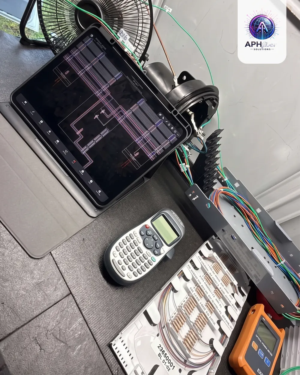 Splice tray, tablet with the network layout and a power meter on a work surface