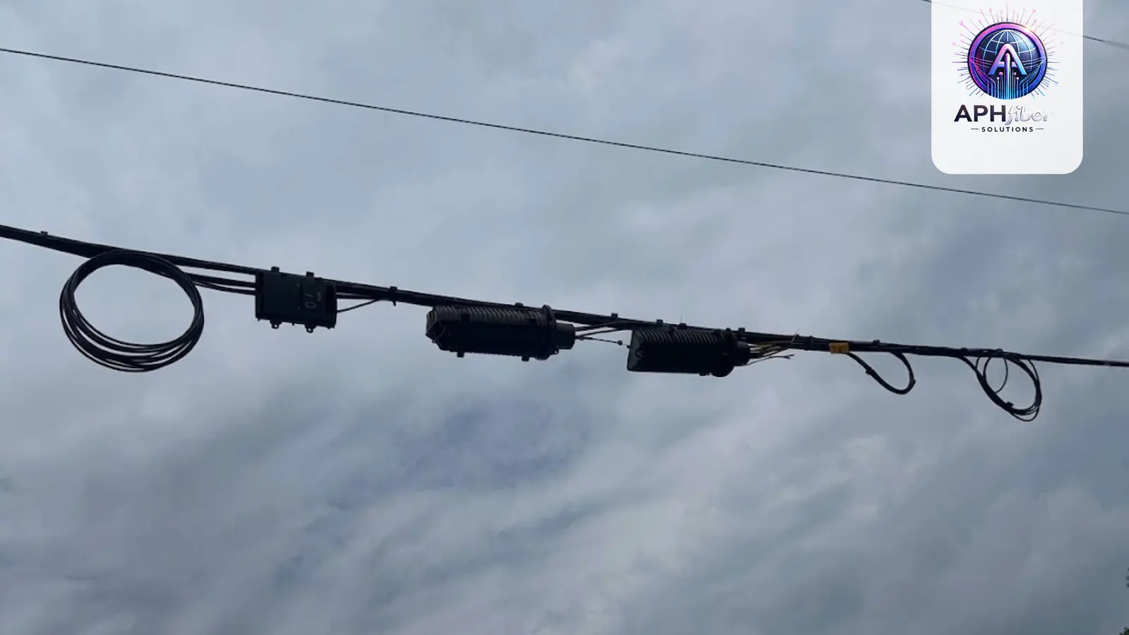 Aerial fiber cable with splice closures hanging over a roadway